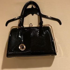 Patent leather black handbag with gold hardware and classic snap top closure